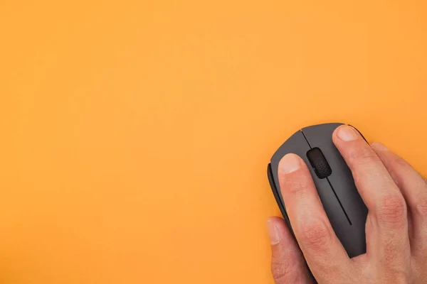 Persona che utilizza il mouse del computer wireless su sfondo giallo — Foto Stock