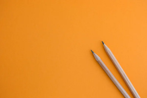 Dos lápices sobre un fondo amarillo — Foto de Stock