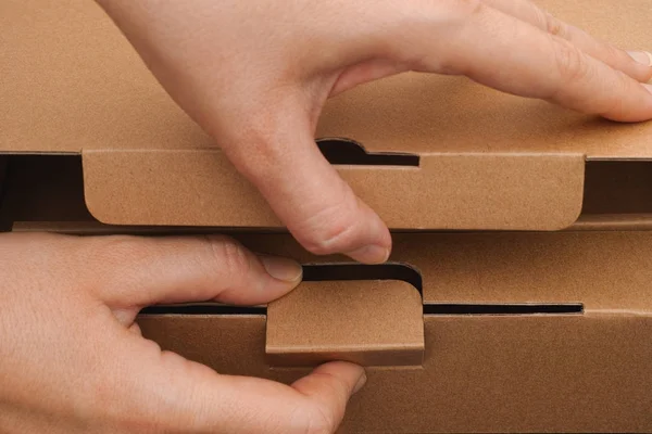 Le mani di persona che aprono una scatola di cartone — Foto Stock