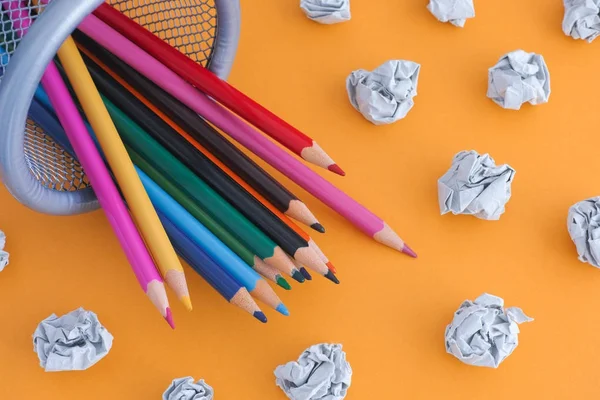 Coloured pencils in a bin with crumpled paper balls near them — Stock Photo, Image