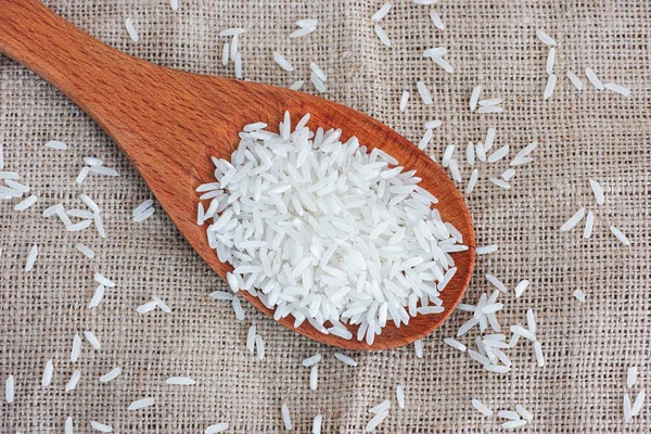 Bílé dlouhé rýže v dřevěnou lžící — Stock fotografie