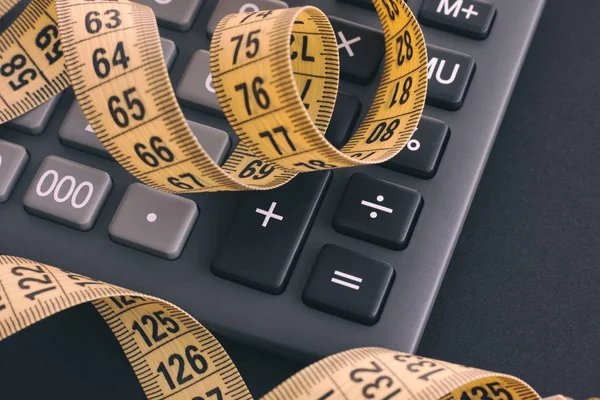 Calculator and yellow tape measure — Stock Photo, Image