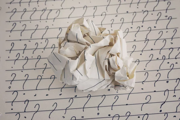 Zerknüllte Papierkugel und Fragezeichen auf liniertem Papier — Stockfoto