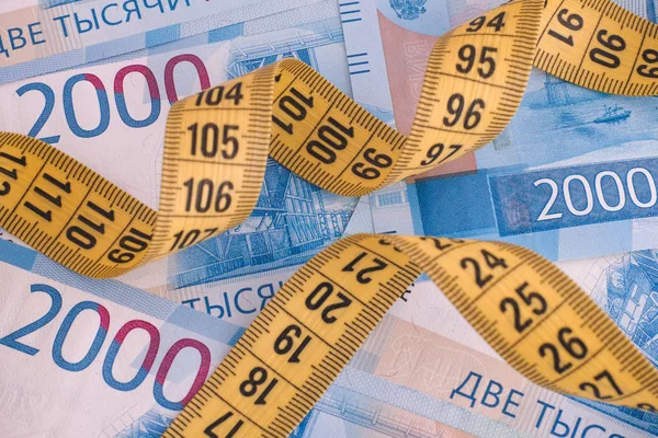 Two thousand ruble banknotes and measuring tape — Stock Photo, Image