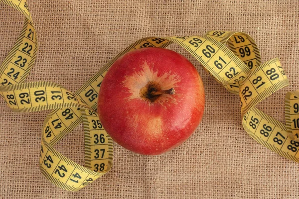 Красное яблоко и жёлтая измерительная лента — стоковое фото