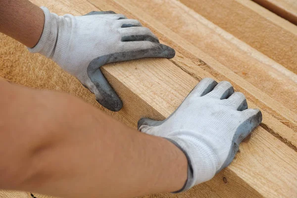 Construction worker grabbing plank of wood — Stock Photo, Image