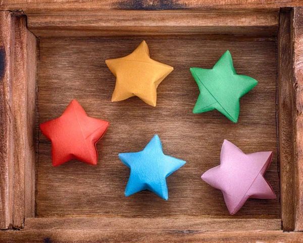 Origami colorato stelle fortunate in una scatola di legno — Foto Stock