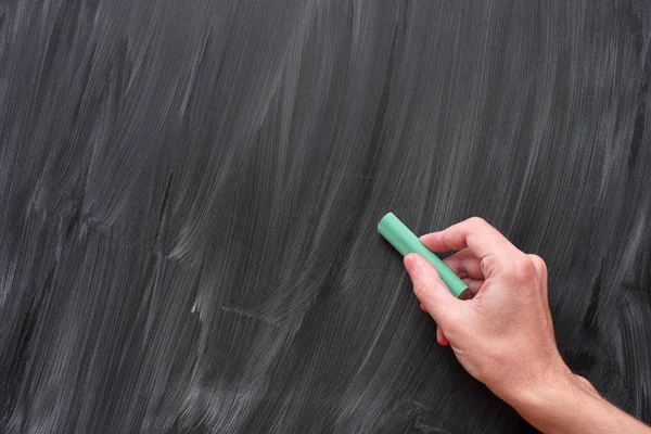 Hand writing on a black chalkboard with green chalk — Stock Photo, Image