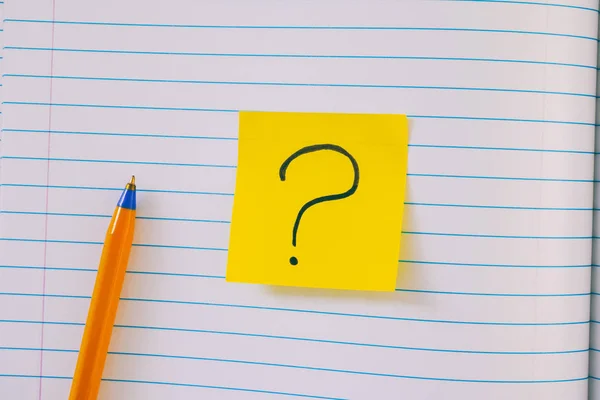 Lined paper notepad with question mark and pen — Stock Photo, Image