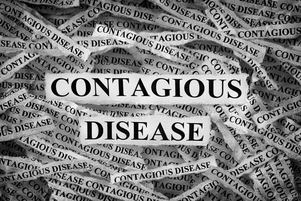 Torn pieces of paper with the words Contagious disease — Stock Photo, Image