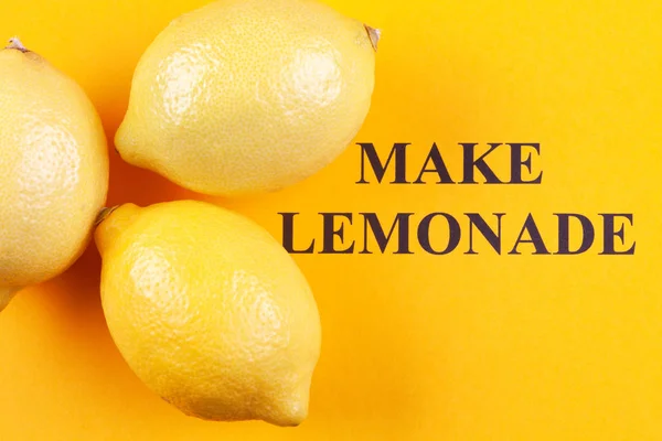Lemons and phrase "Make Lemonade" on a yellow background — Stock Photo, Image