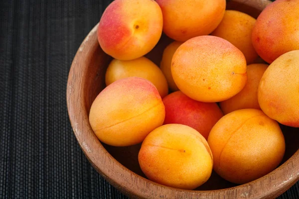 Organic apricots in a wooden bowl — Stock Photo, Image