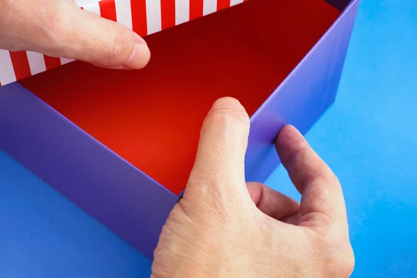 Руки, що відкривають картонну коробку — стокове фото