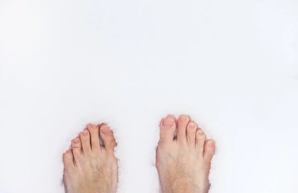 Barefoot man die op sneeuw staat — Stockfoto