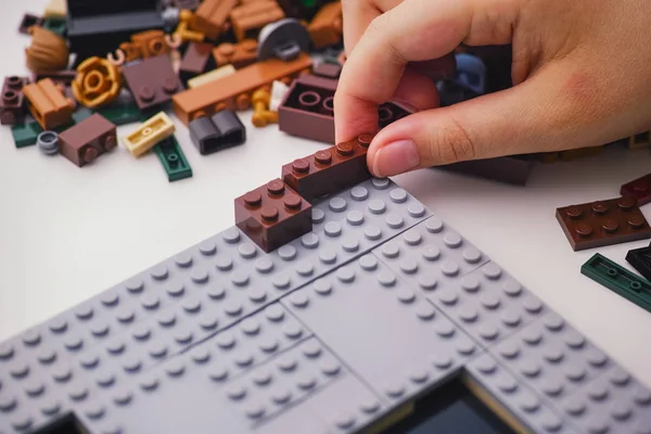 Çocuk tabağa bir lego tuğlası koyuyor — Stok fotoğraf