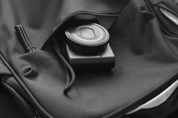 Compact camera inside a backpack. Black and White — Stockfoto