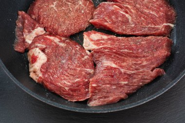 Tavada taze çiğ et, karabiber ve deniz tuzu.