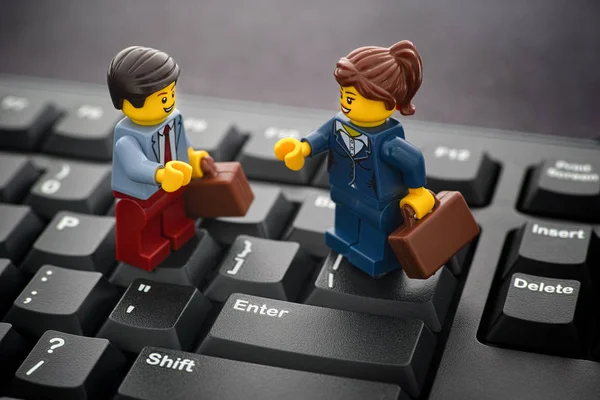 Lego zakenman en zakenvrouw minifiguren op een pc toetsenbord — Stockfoto