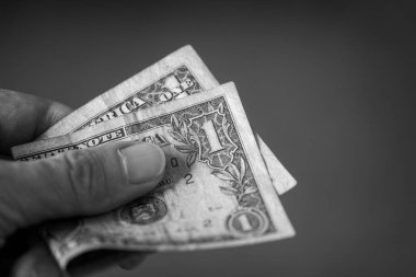 Kişi elinde bir dolar tutar. Siyah ve Beyaz. Kapat..