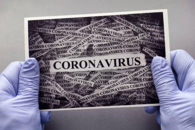 Üzerinde Coronavirus yazan tıbbi eldivenli bir adam. Kapatın. Bu resimde portföyümdeki kendi dosyamı kullandım: 336889634