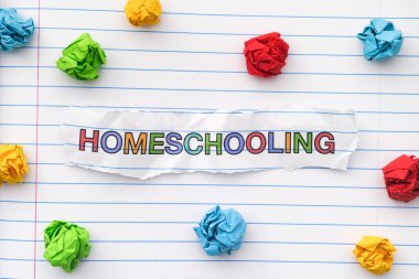 Çizgili bir defter kağıdına buruşmuş kağıt toplarla evde eğitim kelimesi yazılıydı. Kapat..