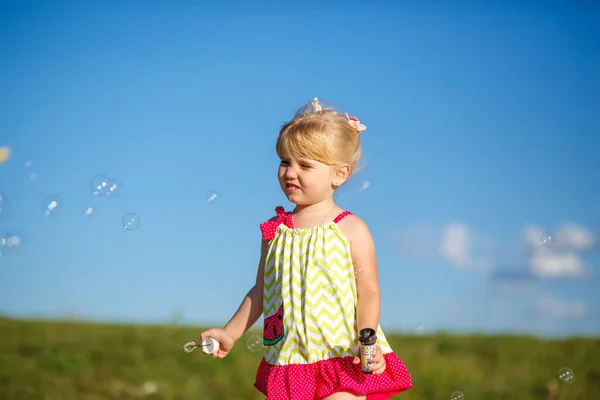 Klein Meisje Speelt Met Zeepbellen Lucht Achtergrond — Stockfoto