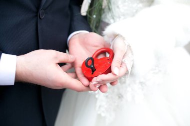 Gelin ve damat ile siyah anahtar, küçük kırmızı kilit ile düğün, elinde seviyorum