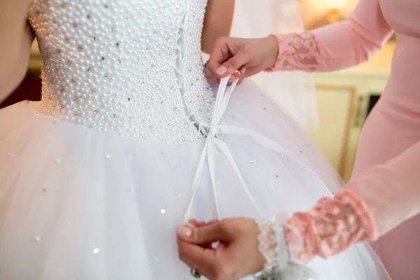 Assistente de arco no vestido de noiva — Fotografia de Stock