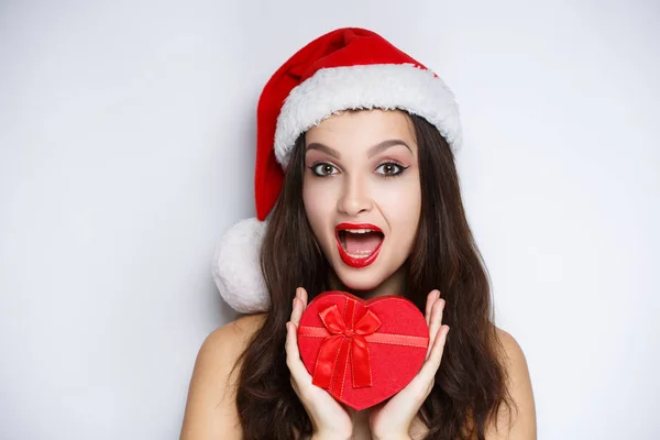 Donna in possesso di cuore rosso, sexy Babbo Natale con presente — Foto Stock