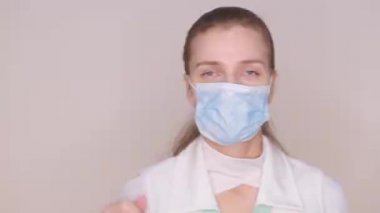 Koruyucu mavi maskeli, beyaz üniformalı kadın doktor. Pankart salgını, virüs koruması. Hastaların grip bağışıklığı olması gerekiyor. İlaçlarda eksiklik, koronavirüs için yeni koruyucu ekipman