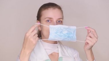 Koruyucu mavi maskeli, beyaz üniformalı kadın doktor. Pankart salgını, virüs koruması. Hastaların grip bağışıklığı olması gerekiyor. İlaçlarda eksiklik, koronavirüs için yeni koruyucu ekipman