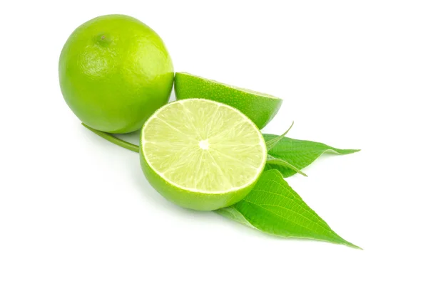 Deux moitiés et du citron vert entier isolé sur du blanc avec des feuilles — Photo