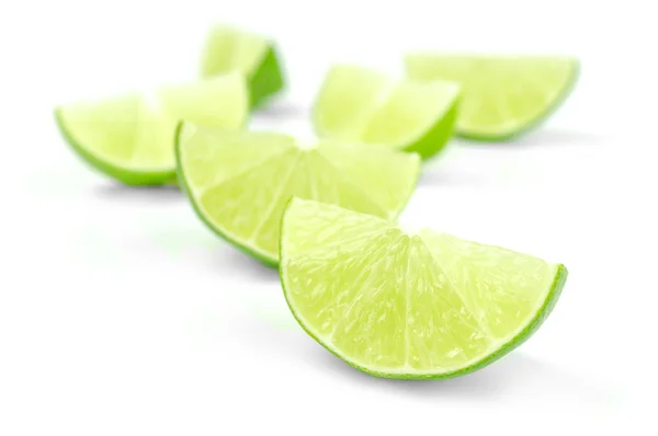 Scattering of fresh lime wedges isolated on a white background — Stock Photo, Image