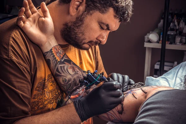 Professional tattooer makes tattoo in tatoo salon — Stock Photo, Image