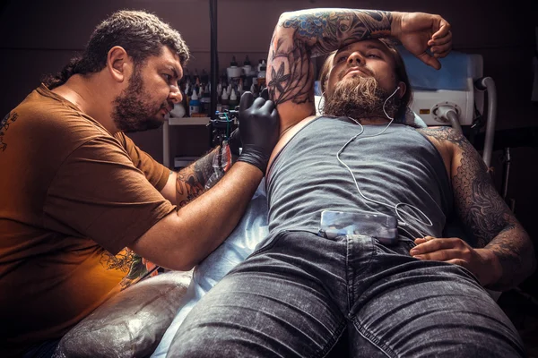 Татуировщик делает татуировки в студии — стоковое фото