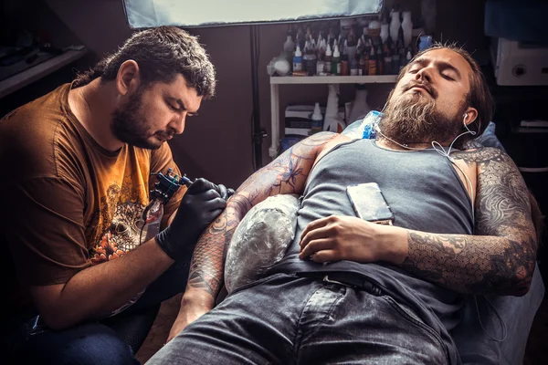 Tattooer makes cool tattoo in tattoo parlor — Stock Photo, Image