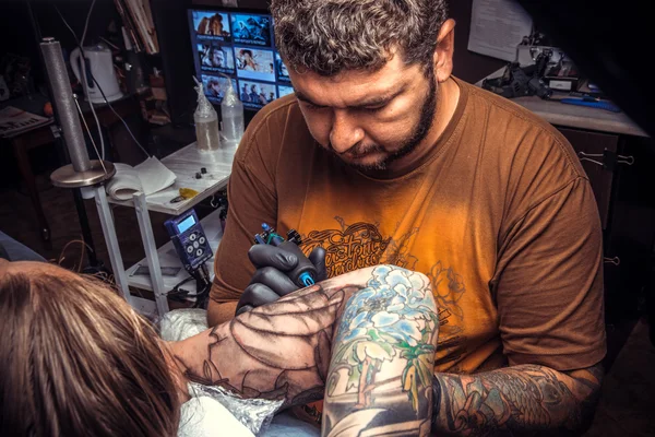 Tattooer は、タトゥー パーラーで入れ墨を作成します。 — ストック写真