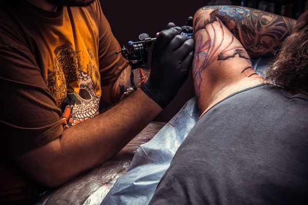 Profesional tatuaje artista hace fresco tatuaje en salón de tatuaje —  Fotos de Stock