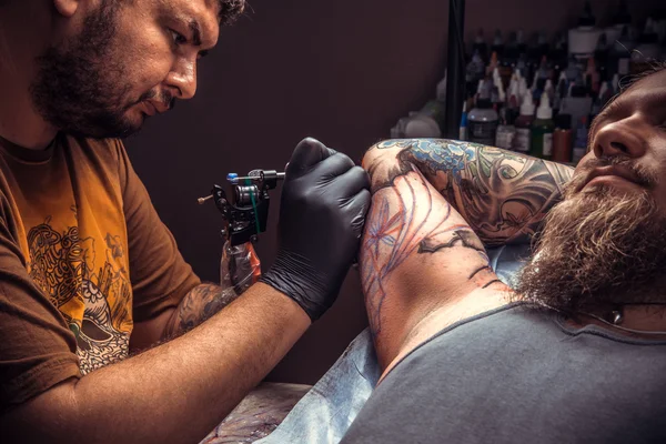 Professional tattooer at work in studio — Stock Photo, Image