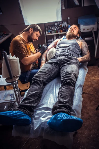 Tattooer は、タトゥー パーラーで入れ墨の写真になります — ストック写真