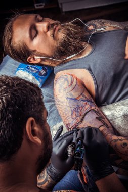 Bir dövme dövme salonu yapma işlemi gösteren profesyonel tattooer