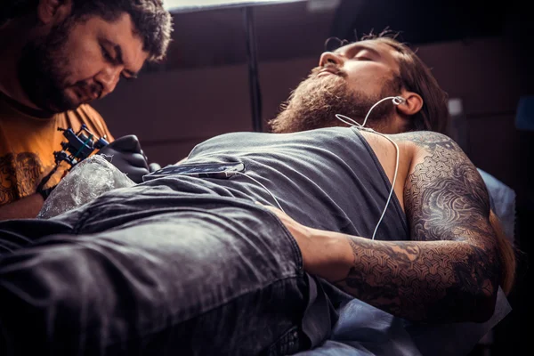 Профессиональный татуировщик делает татуировку в тату-салоне — стоковое фото