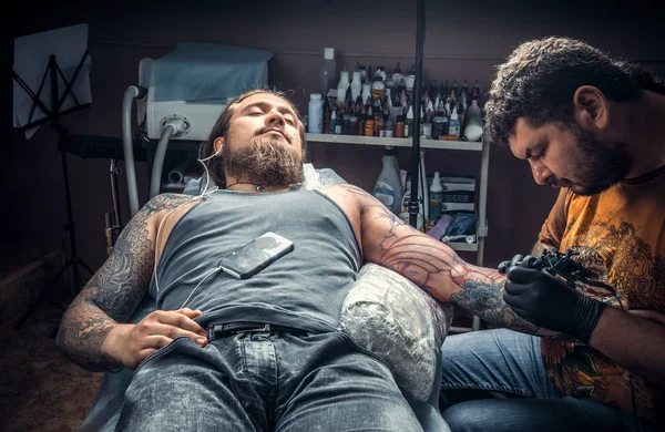 Tattoo specialist working tattooing in tattoo parlor
