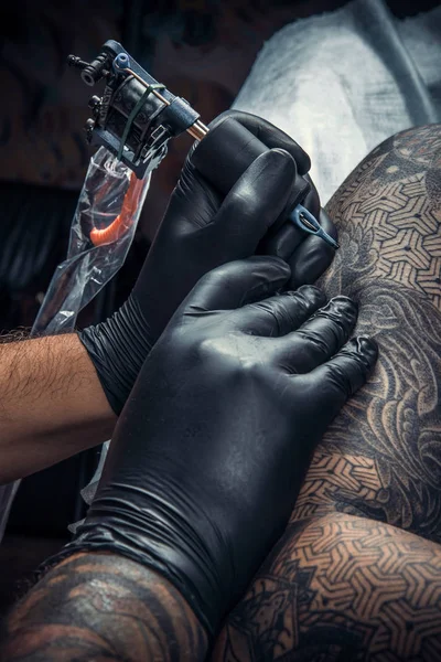 Tatuagem mestre trabalhando tatuagem em sala de tatuagem — Fotografia de Stock