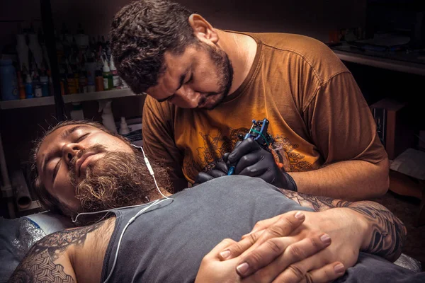 Tattoo specialist makes cool tattoo in tattoo parlor — Stock Photo, Image