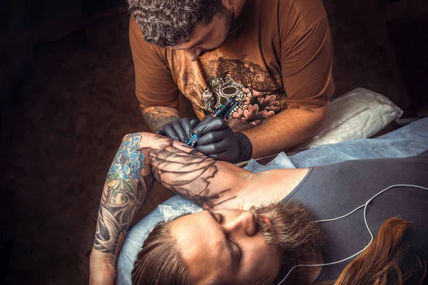 Professional tattooist create tattoo in studio