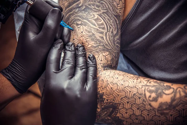 Master working tattooing in tattoo studio./Professional tattooist works in studio.