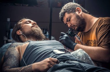 Profesyonel tattooer bir dövme dövme salonu. içinde yapım / profesyonel dövmeci dövme salonu içinde işte.