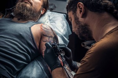 Profesyonel tattooer oluşturmak dövme salonu. / profesyonel dövmeci dövme dövme salonunda yapma süreci gösterilen.