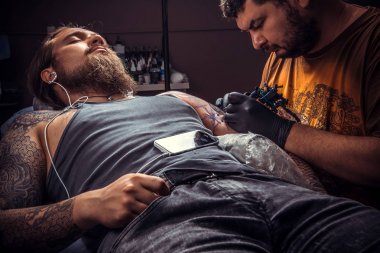 Profesyonel tattooer dövmeci dövme yapıyor